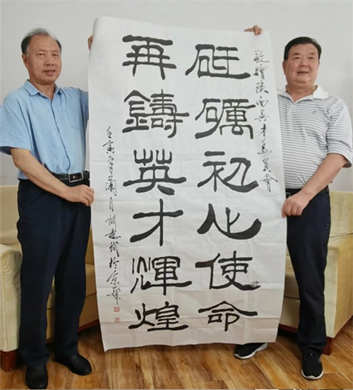 刘建武（左一）为陕西英才委员会赠送书法作品